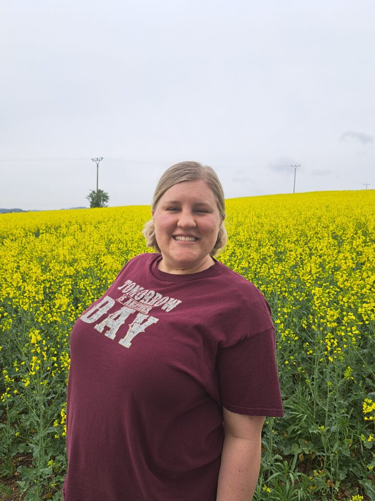 Mack standing in canola flower fields